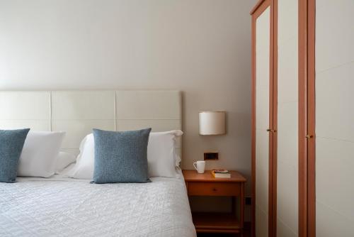 a bedroom with a bed with blue and white pillows at Doria Park Hotel in Lerici