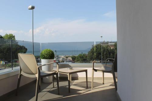 a balcony with two chairs and a table and a window at Hotel Cristal in Sirmione