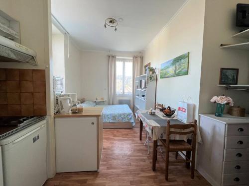 une cuisine avec une table et une chambre avec un lit dans l'établissement Studio lumineux à Cambo-les-Bains, proche thermes, coin nuit, kitchenette, internet, animaux acceptés - FR-1-495-10, à Cambo-les-Bains