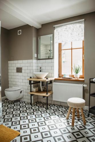 a bathroom with a sink and a toilet and a window at Joy Aparthotel Keilberg in Klínovec