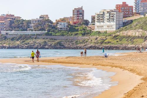 a group of people walking on the beach at Cullera Panoramic Sea Views Apartment in Cullera