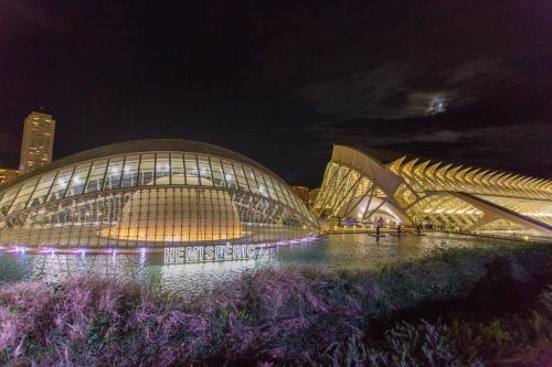 a view of a building at night with purple flowers at Cullera Panoramic Sea Views Apartment in Cullera