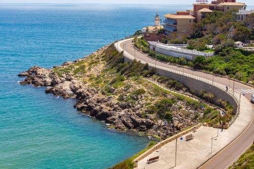 a road next to the ocean next to a beach at Cullera Panoramic Sea Views Apartment in Cullera