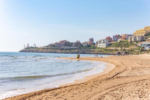 a sandy beach with a city in the background at Cullera Panoramic Sea Views Apartment in Cullera
