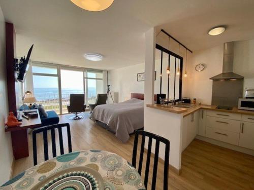 une chambre avec un lit et un bureau et une cuisine dans l'établissement Studio refait à neuf 35m² à Quiberon avec WIFI, Parking et loggia vue mer - FR-1-478-39, à Quiberon
