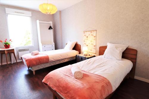 1 dormitorio con 2 camas y ventana en HOLAVRE, en Arradon