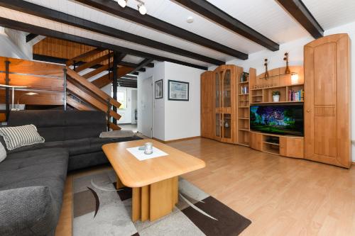 ein Wohnzimmer mit einem Sofa und einem Tisch in der Unterkunft Haus Nordseepferdchen in Bensersiel