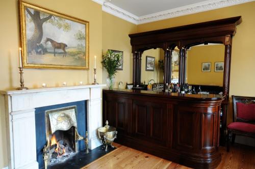 a living room with a fireplace and a picture of a horse at Ashbrook Arms Townhouse and Restaurant in Durrow