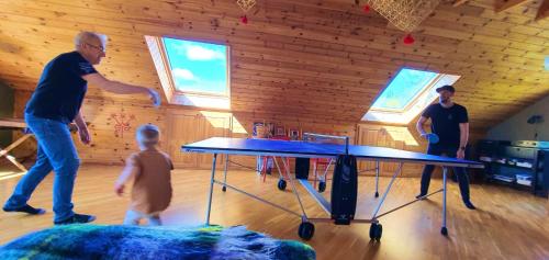 two men and a child playing a ping pong table at Pilava in Roja