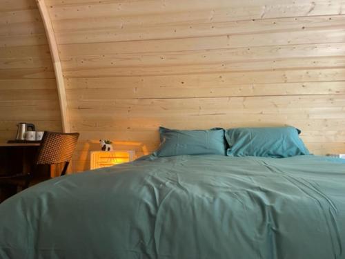 a bed in a room with a wooden wall at La cabane du Panda in Abrest