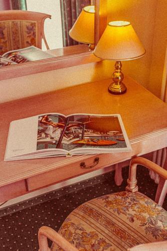 a table with a lamp and a book on it at Amadeus Ora & Amore in Caldaro