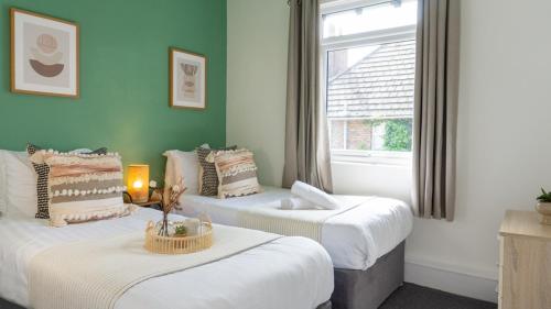 dwa łóżka w pokoju z oknem w obiekcie Air Host and Stay - Bevington house modern chic home sleeps 8 w Liverpoolu