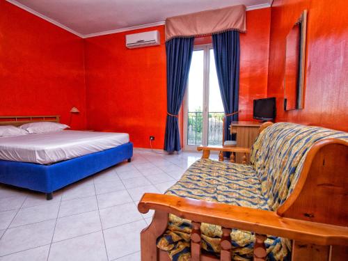 a bedroom with a bed and a couch and a tv at Hotel Silverado in Aversa