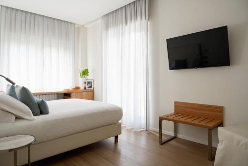um quarto com uma cama e uma televisão na parede em Doria Park Hotel em Lerici