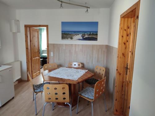 a dining room with a wooden table and chairs at Zum Boddenblick in Breege