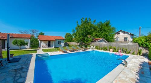 a swimming pool in a yard with chairs and a fence at Ranc Vitina in Ljubuški