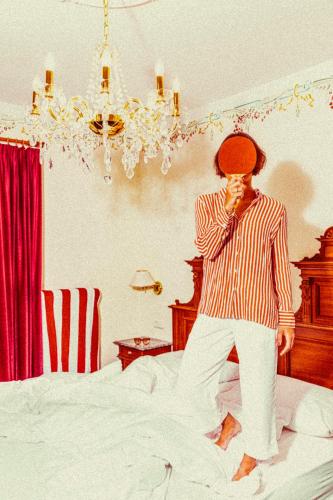 a man standing on a bed adjusting his tie at Amadeus Ora & Amore in Caldaro