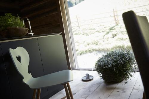 a white chair sitting in a room with a window at Auhäuslalm in Maria Alm am Steinernen Meer