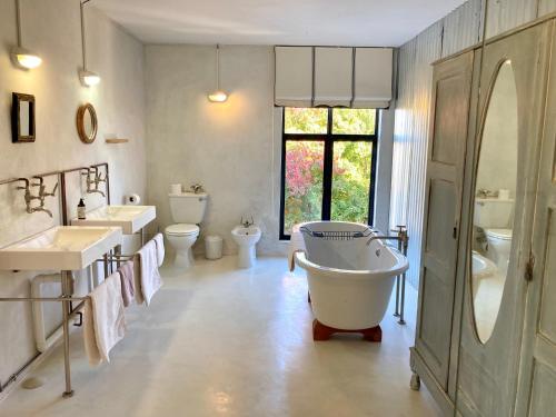 a bathroom with two sinks and a tub and two toilets at Mission House in Howick