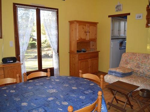 un salon avec une table et une cuisine dans l'établissement Maison boisée proche de la plage des Coraux, 2 chambres, terrasse, parking et jardin - FR-1-22-283, à La Tranche-sur-Mer