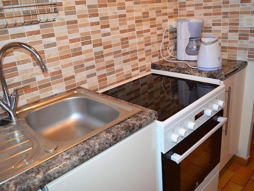 une cuisine avec un évier et un plan de travail dans l'établissement Maison boisée proche de la plage des Coraux, 2 chambres, terrasse, parking et jardin - FR-1-22-283, à La Tranche-sur-Mer