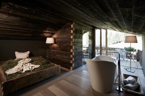 a room with a bed and a tub in a room at Auhäuslalm in Maria Alm am Steinernen Meer