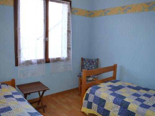 une chambre avec deux lits et une chaise et une fenêtre dans l'établissement Maison boisée proche de la plage des Coraux, 2 chambres, terrasse, parking et jardin - FR-1-22-283, à La Tranche-sur-Mer