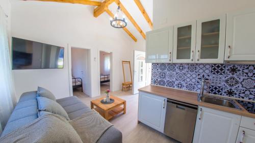 a living room with a blue couch and a kitchen at Ranc Vitina in Ljubuški