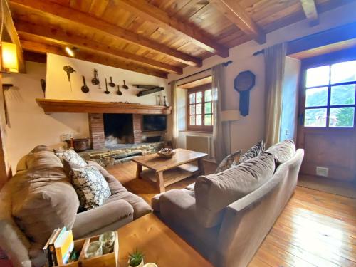 a living room with a couch and a fireplace at Pleta Ordino 18, Duplex rustico con chimenea, Ordino, zona vallnord in Ordino