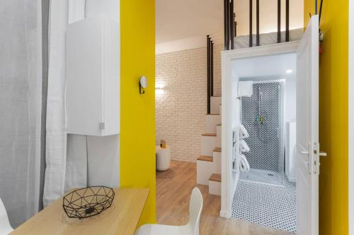 Cette chambre est dotée d'un mur jaune et d'une salle de bains avec douche. dans l'établissement Chic Saint-Germain-des-Prés Studio for 4 - Prime location, à Paris