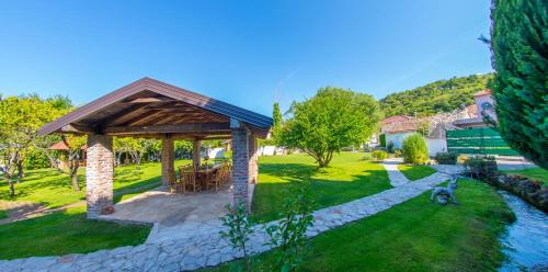 a gazebo in a yard next to a river at Ranc Vitina in Ljubuški