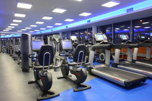 a gym with rows of treadmills and elliptical machines at Tempus Club Garni Hotel in Bratislava