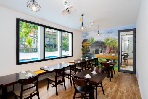 a dining room with tables and chairs and windows at KA VILLA - AN BANG BEACH, Free pick up 3 nights in Hoi An