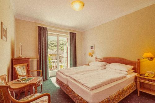 a hotel room with a bed and a window at Amadeus Ora & Amore in Caldaro