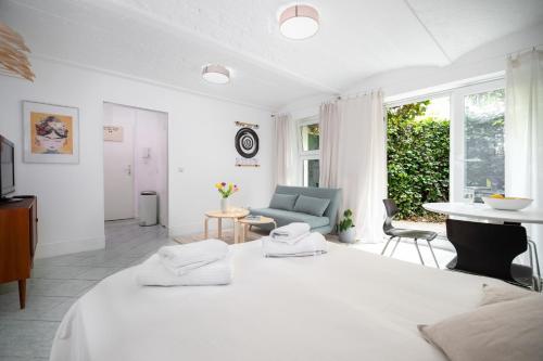 ein weißes Zimmer mit einem Bett und einem Sofa in der Unterkunft City Hideaway with Terrace in Berlin