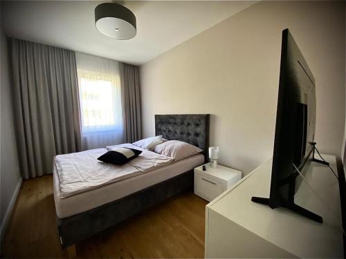 a bedroom with a bed and a flat screen tv at Apartament w obiekcie Platinum Rewal in Rewal