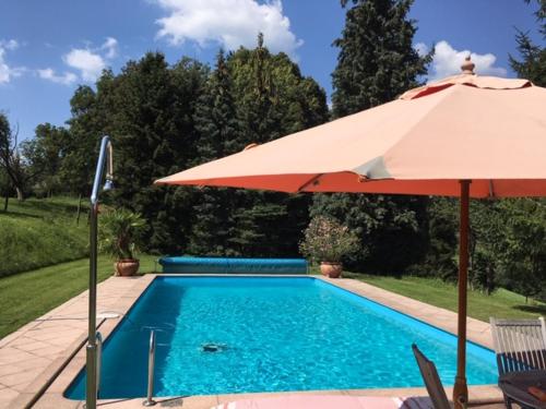 einen Pool mit Sonnenschirm und Pool in der Unterkunft Camping f Selbstversorger Gut Jägerhof in Semriach
