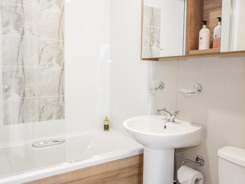 La salle de bains est pourvue d'un lavabo, d'une baignoire et de toilettes. dans l'établissement Serena Lodge, à Jedburgh