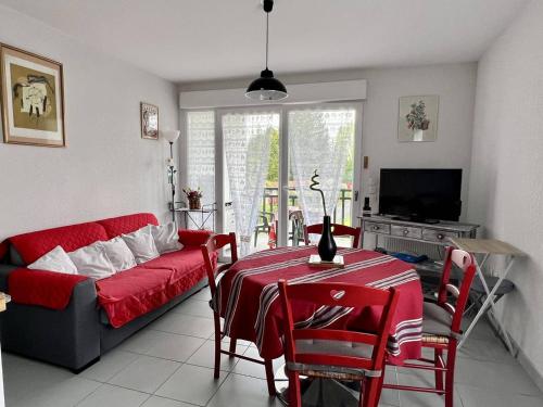 un salon avec un canapé rouge et une table dans l'établissement Charmant T2, centre Cambo, calme, Tt confort, terrasse, parking, proche commerces - FR-1-495-5, à Cambo-les-Bains