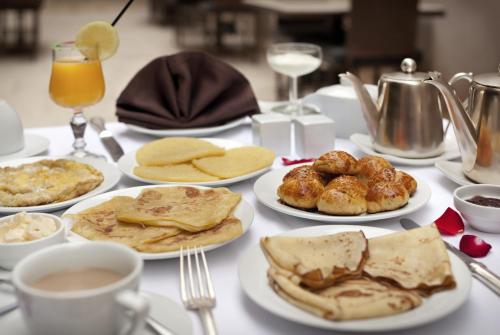 une table garnie d'assiettes de nourriture et de boissons pour le petit-déjeuner dans l'établissement Villa Makassar, à Marrakech