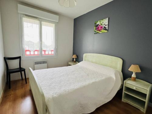 1 dormitorio con 1 cama blanca y 1 silla en Appartement Cambo-les-Bains, 2 pièces, 2 personnes - FR-1-495-8, en Cambo-les-Bains