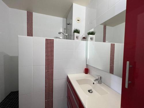 a white bathroom with a sink and a mirror at Appartement T2 confortable avec terrasse sud et parking, au calme, proche commerces, petit animal accepté - FR-1-495-6 in Cambo-les-Bains