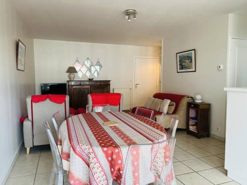 a dining room with a table and red chairs at Appartement Cambo-les-Bains, 2 pièces, 3 personnes - FR-1-495-9 in Cambo-les-Bains