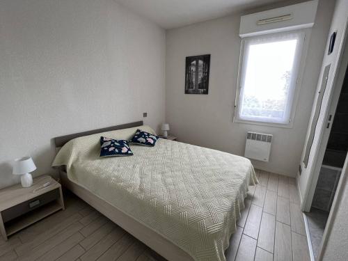 une chambre avec un lit avec deux oreillers dessus dans l'établissement Appartement T2 Confortable avec Terrasse, Proche Centre Ville et Thermes, Cambo-les-Bains - FR-1-495-30, à Cambo-les-Bains