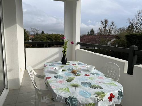une table avec un vase au-dessus d'un balcon dans l'établissement Appartement T2 Confortable avec Terrasse, Proche Centre Ville et Thermes, Cambo-les-Bains - FR-1-495-30, à Cambo-les-Bains