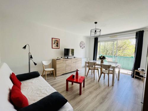 un salon avec un canapé et une table dans l'établissement T2 calme avec balcon, parking et internet, Cambo-les-Bains - FR-1-495-46, à Cambo-les-Bains