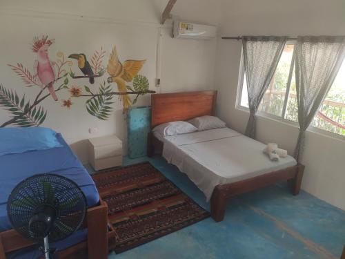 a bedroom with a bed and a window at El Zoo Hostel, Bar & Pool in Palomino