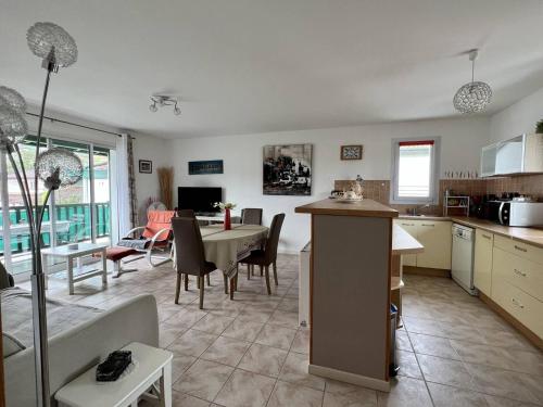 une cuisine et un salon avec une table et une salle à manger dans l'établissement Appartement T2 confortable à Cambo-les-Bains avec terrasse et parking proche centre et thermes - FR-1-495-58, à Cambo-les-Bains