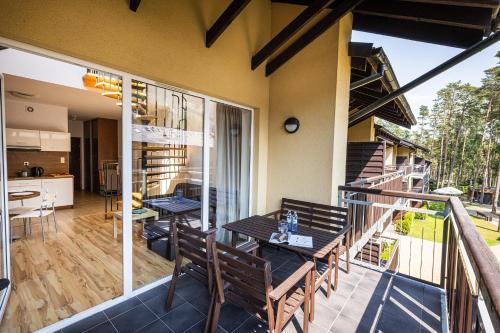 a patio with a table and chairs on a balcony at Natura Resort in Pogorzelica