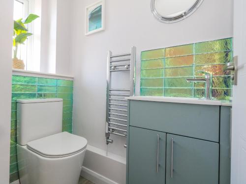 a bathroom with a toilet and a sink and a mirror at Mermaid House in Weymouth
